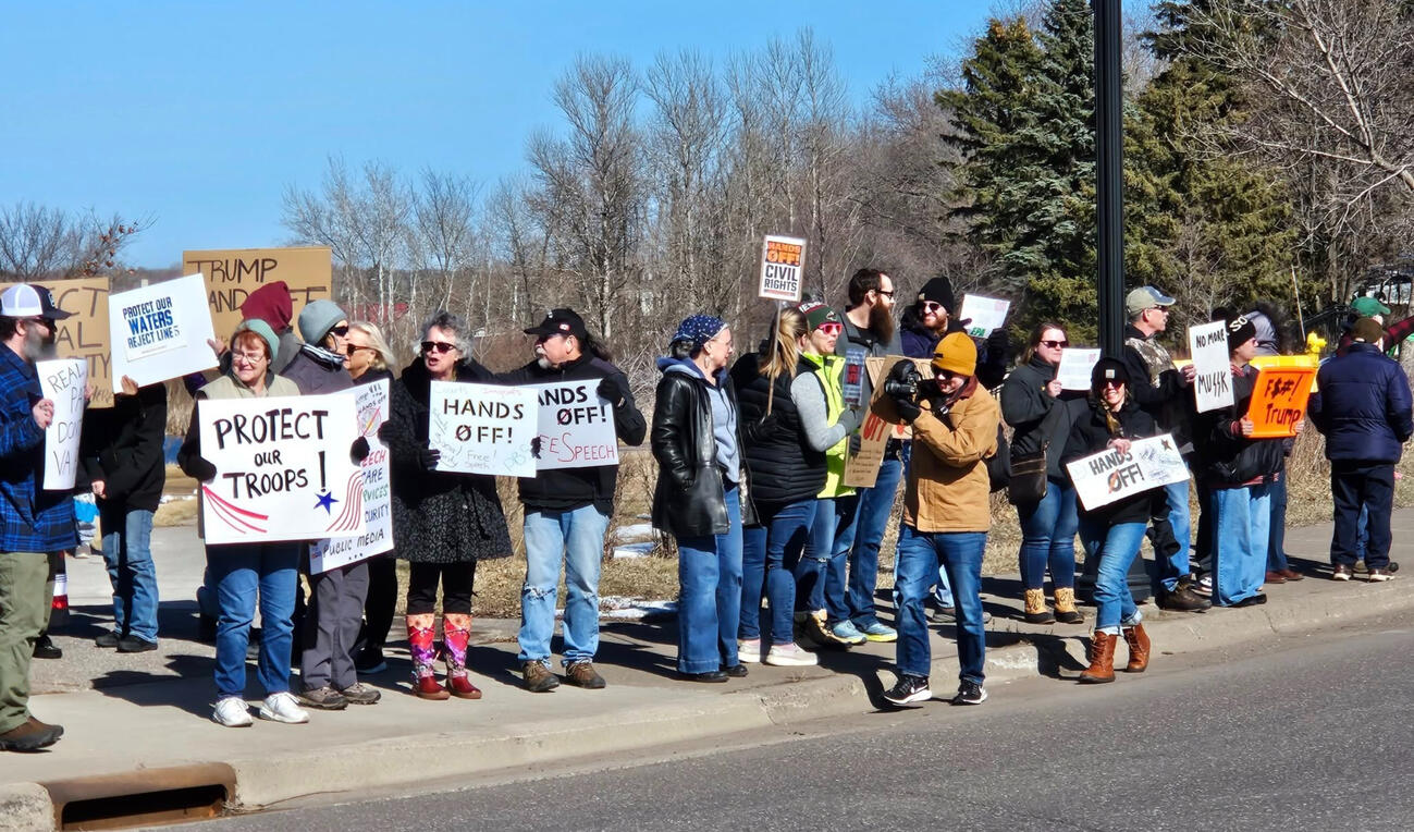 Protest participants holding advocacy signs during the 2025 Hands Off demonstration in Cloquet, Minnesota